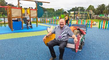 Photo of Cllr Murphy sitting on a see-saw