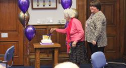 Marjorie (Madge) Cotterell cuts the cake with Cllr Sam Clark